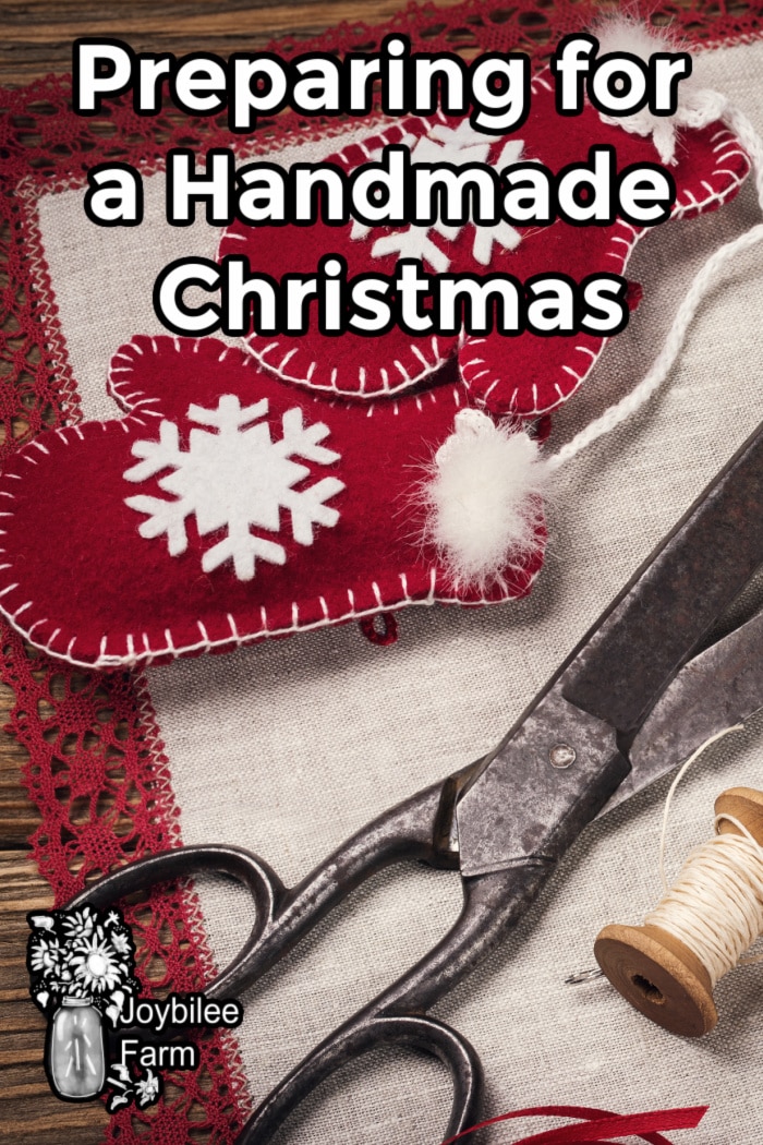 Christmas mitten decorations alonside antique scissors and a spool of heavy thread.