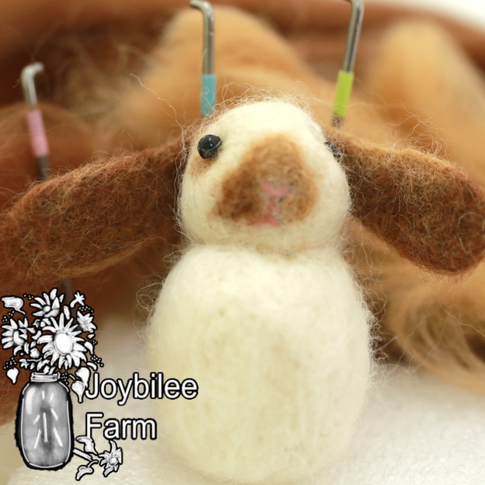 needle felted 3d rabbit with wool and needle felting needles in background