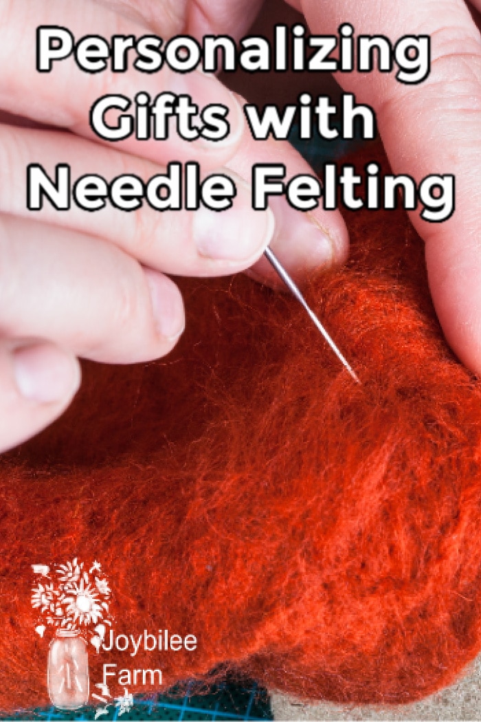 hands needle felting on reddish wool