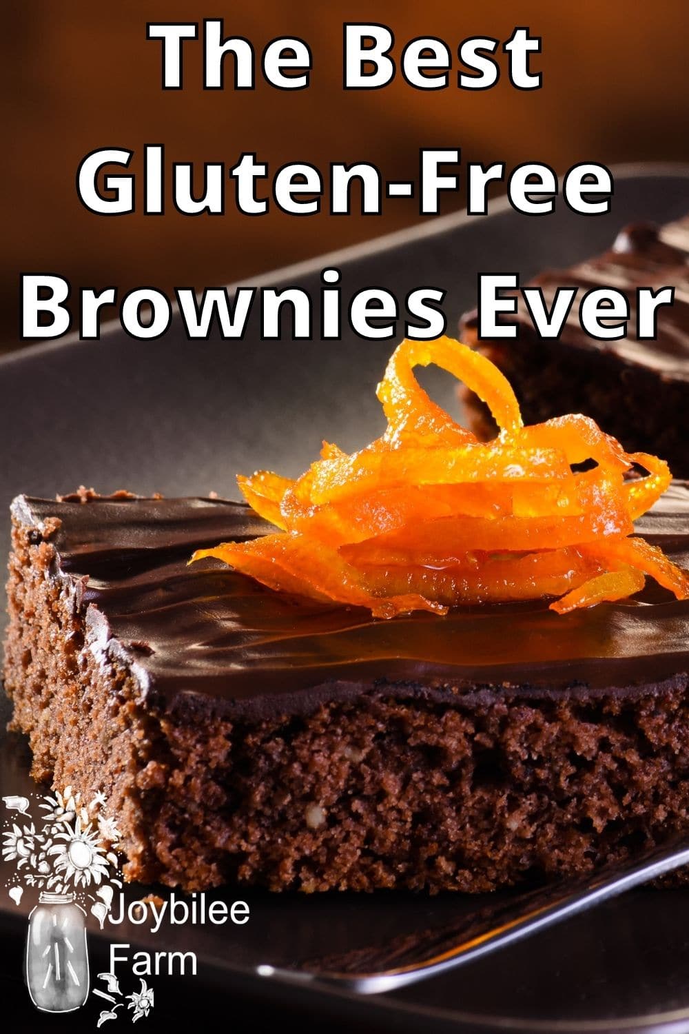 Brownies, topped with chocolate and candied orange peel on a grey tray.