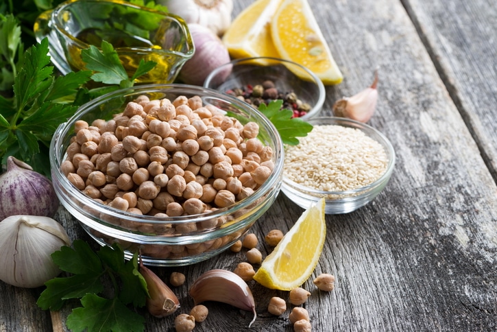 Dried chickpeas, sesame seeds, lemon, and garlic ingredients to make hummus dip at home.