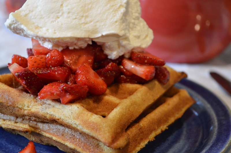 Fresh made waffles with strawberries and whipped cream.