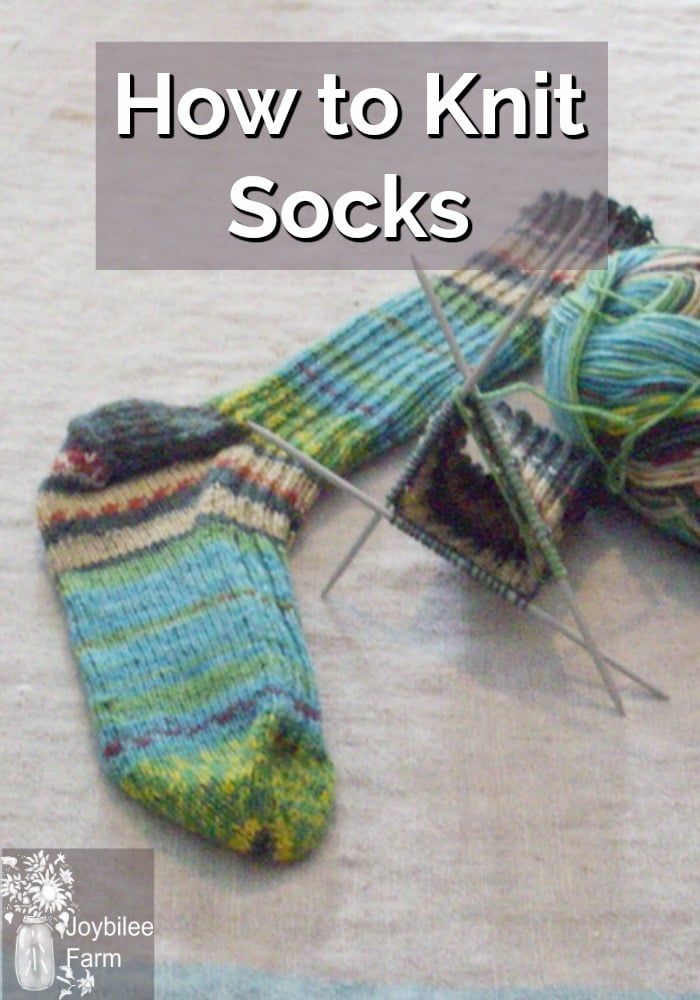 A ball of yarn, one knit sock and another started on 3 needles.