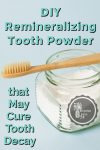 Tooth powder with a bamboo toothbrush sitting on top