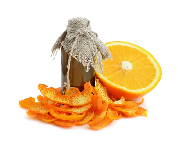Dried orange peels, a fresh sliced orange and a bottle of homemade orange extract