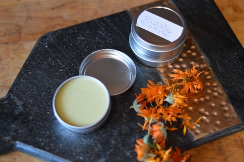 Dried calendula flowers and salve on a cutting board