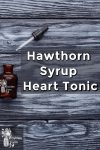 Bottle and bottle dripper on wooden background