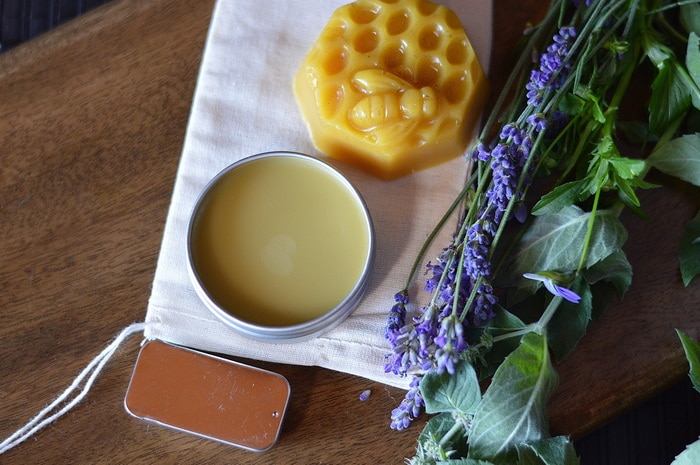 healing Salves sitting by fresh lavender and other herbs