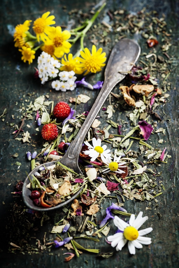 dry herbs and flowers with a silver spoon