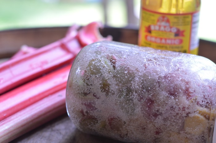 Rhubarb shrub in a glass jar by fresh rhubarb and apple cider vinegar