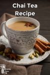 Chai tea in a white mug with spices on the saucer