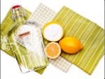A glass bottle of vinegar and sliced lemons