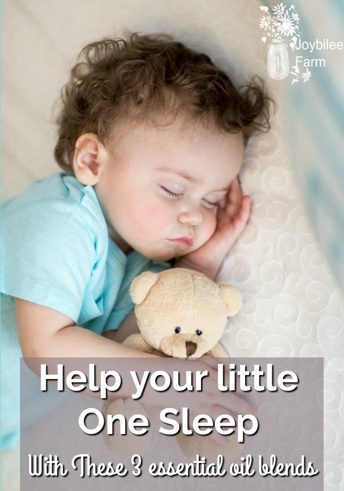 Sleeping baby cuddling a teddy bear