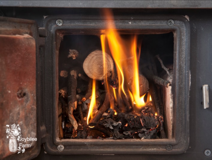 open woodstove door with wood ash uses