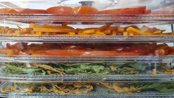 Blanching vegetables and placing them on dehydrator racks