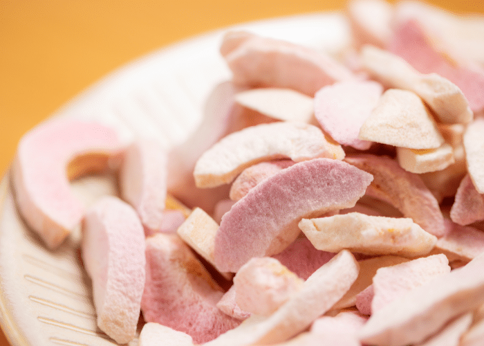 a bowl of freeze dried fruit, peeled and sliced peaches